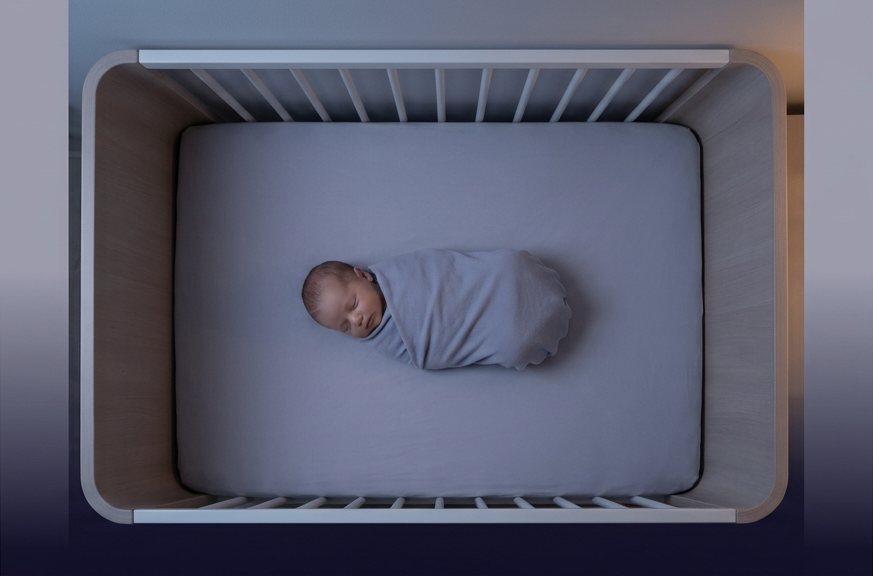 Sleeping baby in a softly lit crib