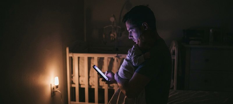 Exhausted father holding his baby during a difficult night